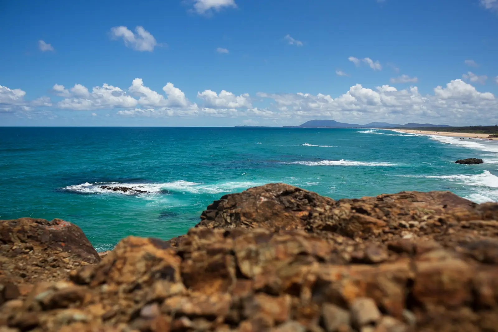 Turquoise surf breaking over a rocky headland