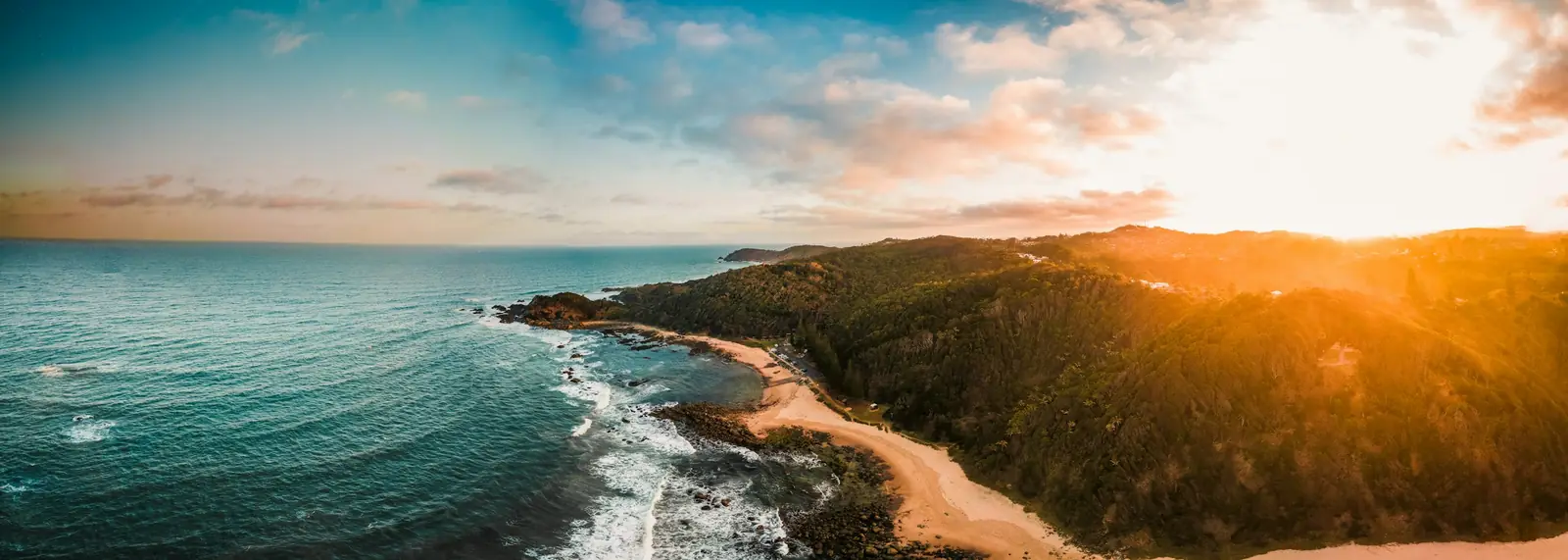 Aerial view of a coastal headland and beach at sunset