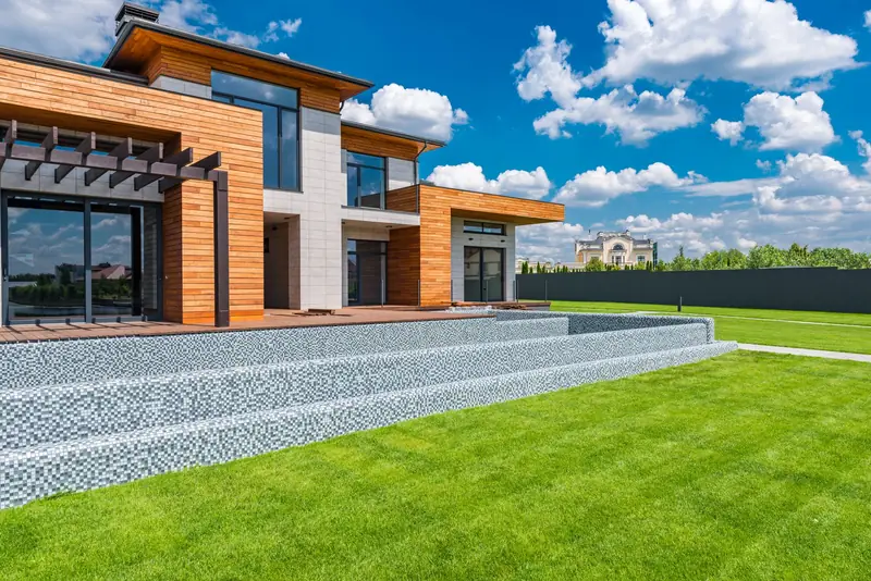 Two-storey new home with timber cladding and a wide lawn